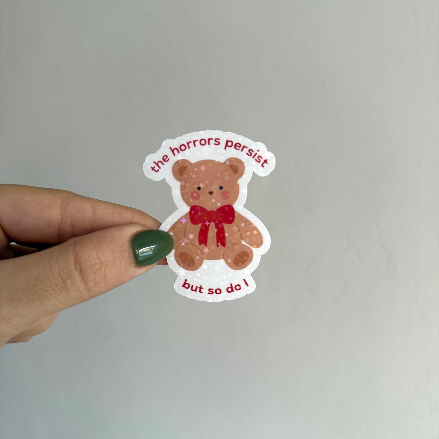 Cute holographic teddy bear sticker that says "the horrors persist but so do I". Waterproof, scratch resistant. Perfect for journals, laptops & more.