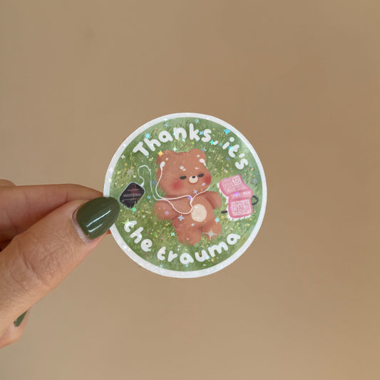 a soft little bear standing in a meadow with fairy lights and a pink therapy box 🐻✨ reads "thanks, it's the trauma" — for everyone who processes their feelings with humor and aesthetics.